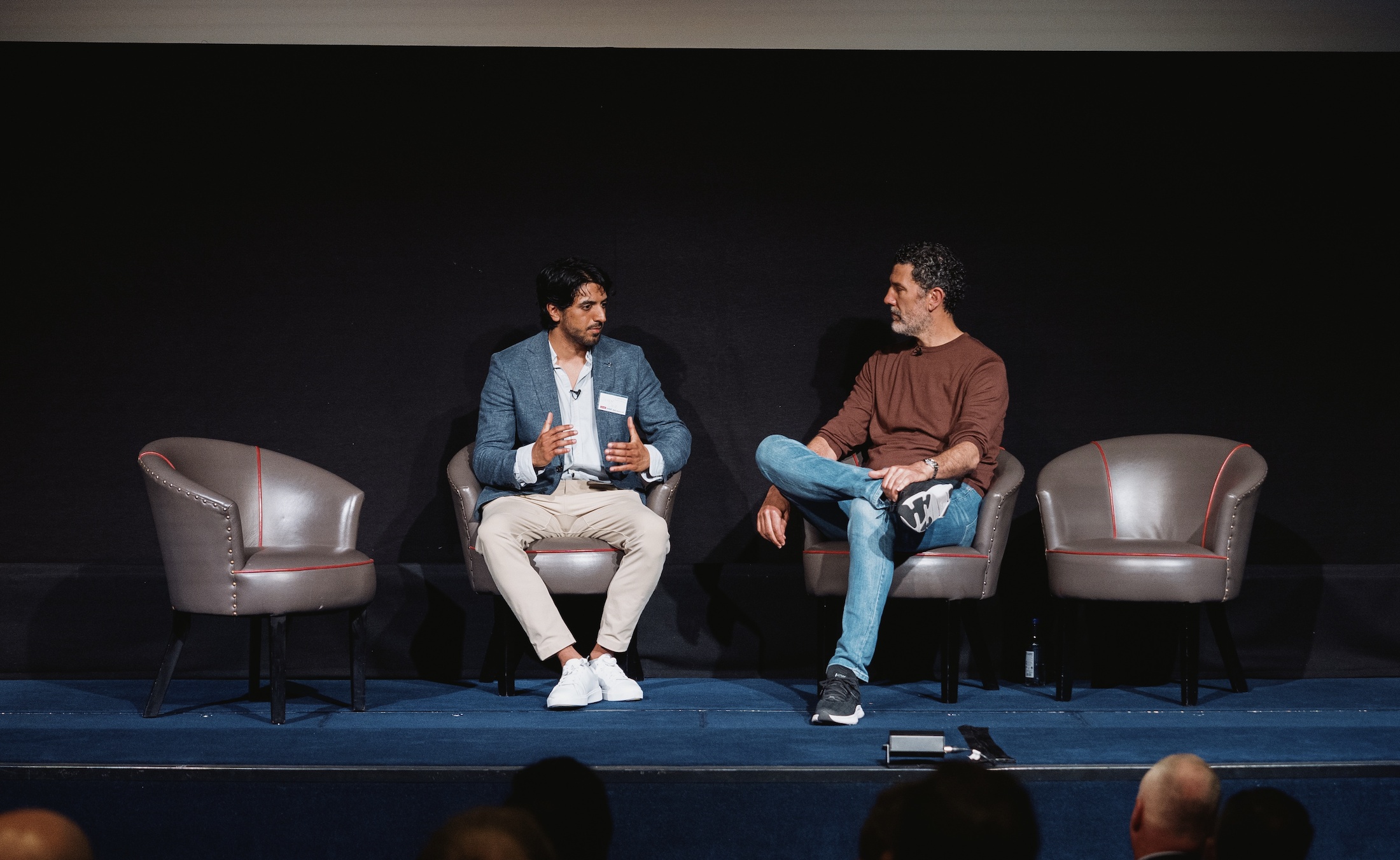 Deven Orie, seated on the left, speaking onstage at the 2025 Sports Loft Summit in London