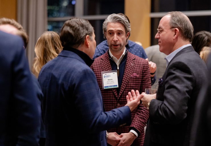 Devin Carty, at center in a checked jacket, talking with fellow Council members at a Nashville networking event