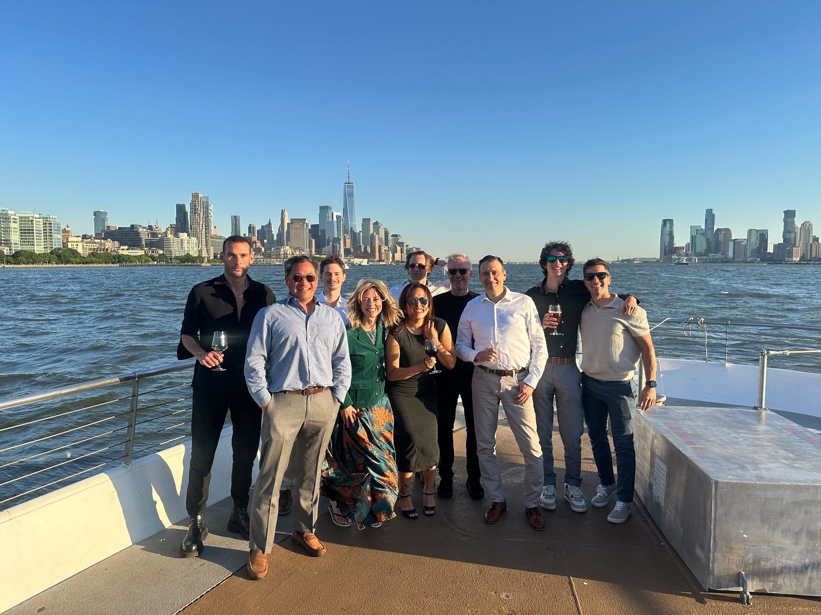 The DeweyLearn team standing together on a boat with the New York skyline behind them
