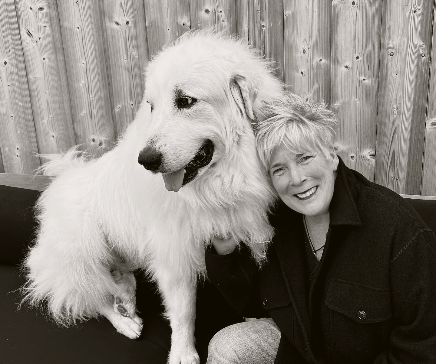 Diane Smith smiling beside a large white dog