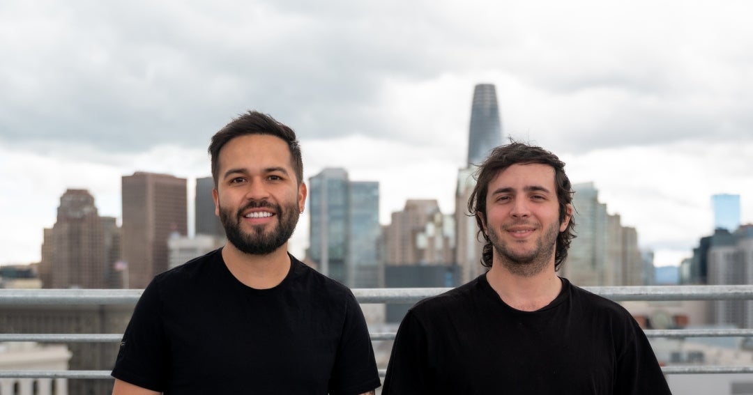 Callbook AI co-founders Diego Avellaneda and Daniel Martínez standing in front of the San Francisco skyline
