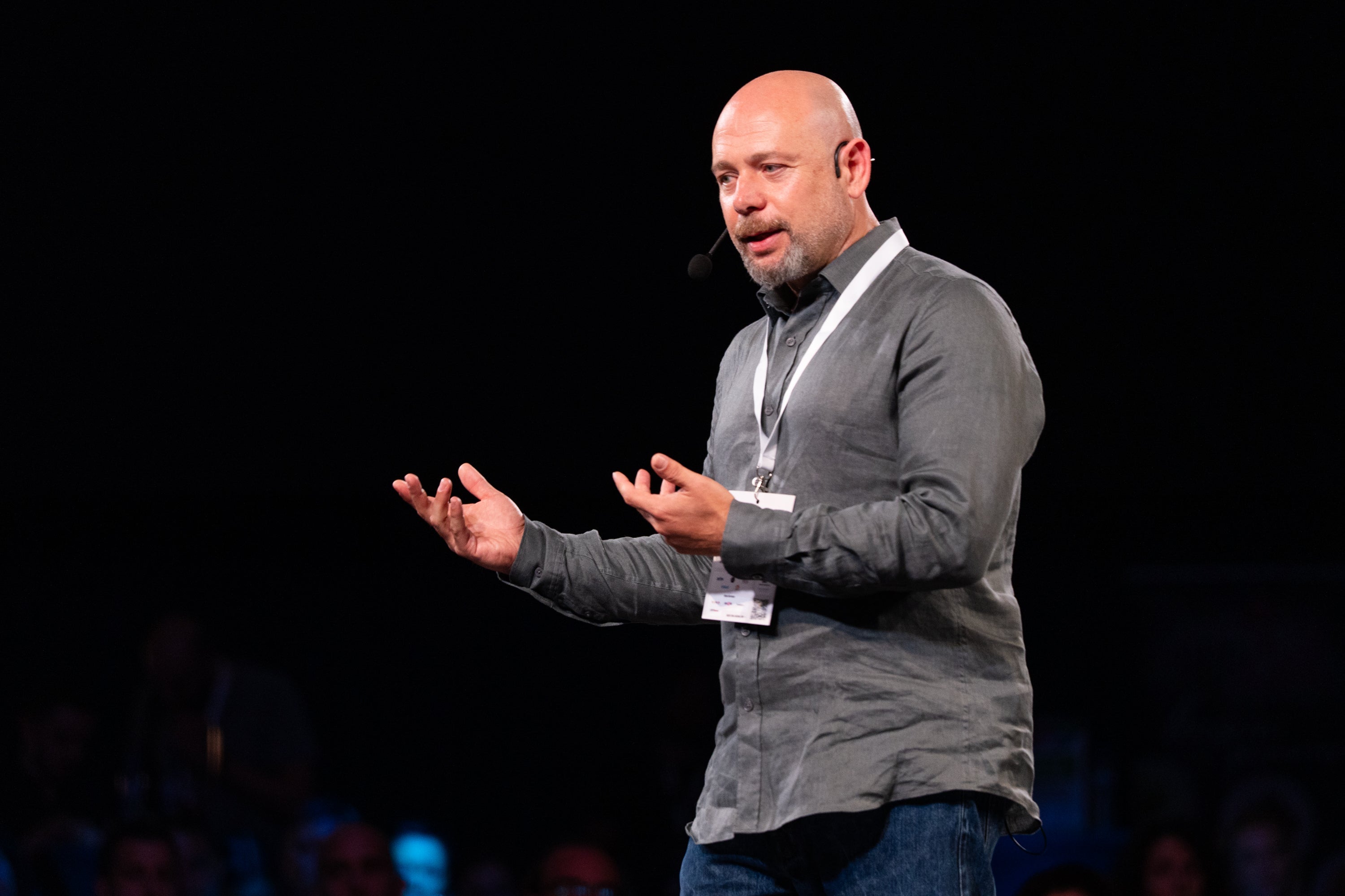 Dimitar Dimitrov speaking onstage at Webit 2025, wearing a headset microphone and gesturing with both hands