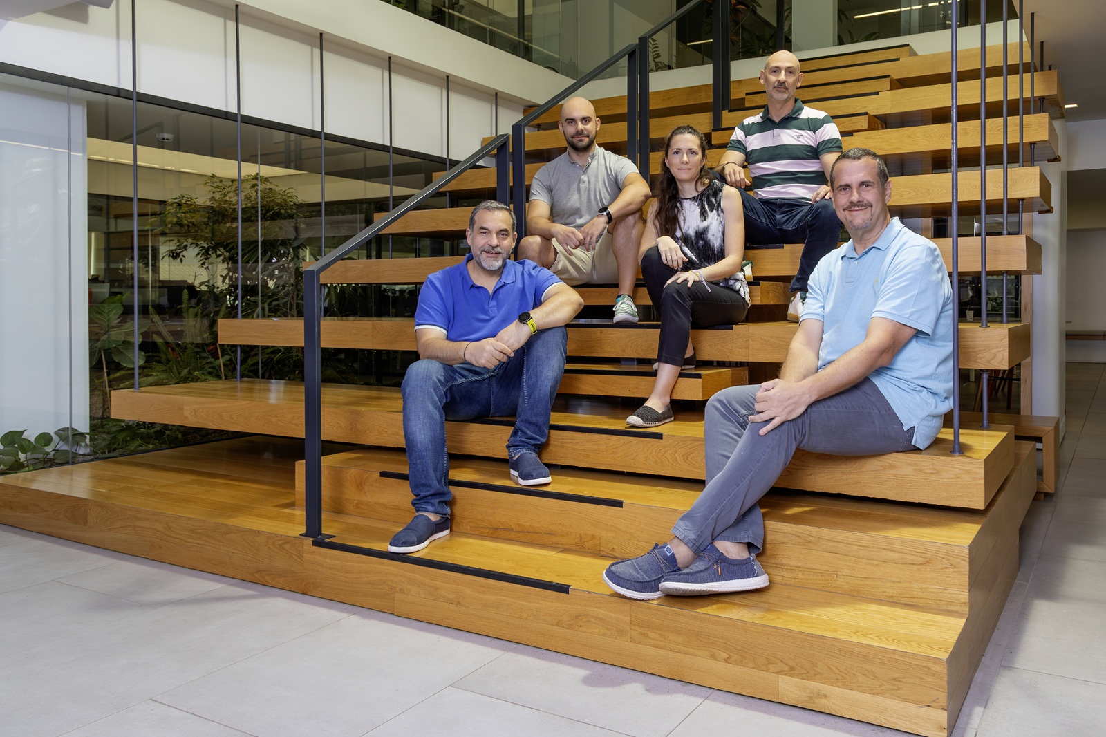 Dimitris Tsingos with colleagues seated on a broad wooden staircase