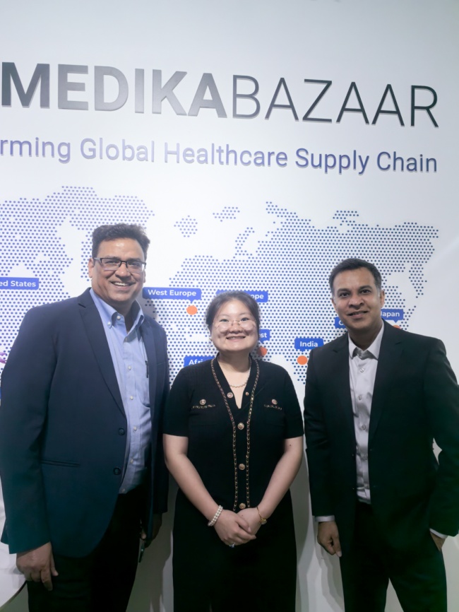 Dinesh Lodha, left, with China general manager Lin Meihan, centre, and a colleague in front of a Medikabazaar world map.