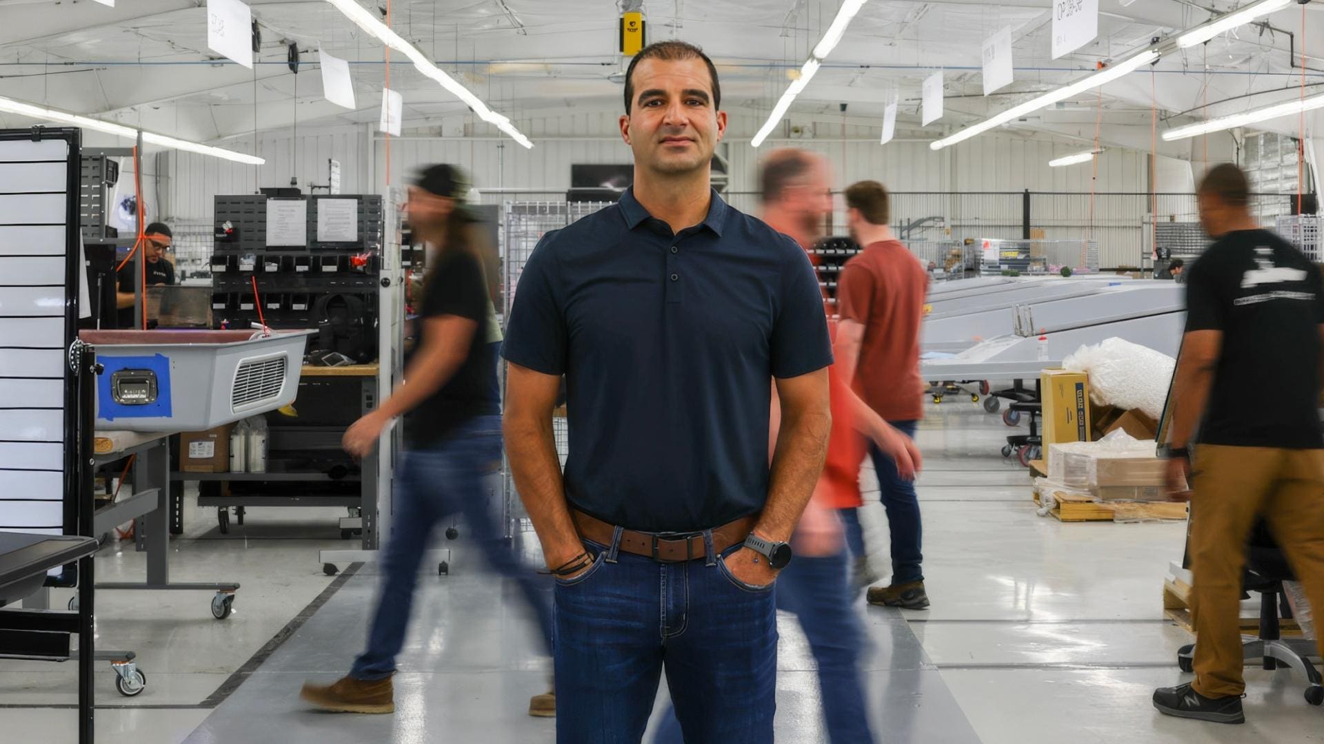 Dino Mavrookas standing on Saronic's factory floor as workers move behind him