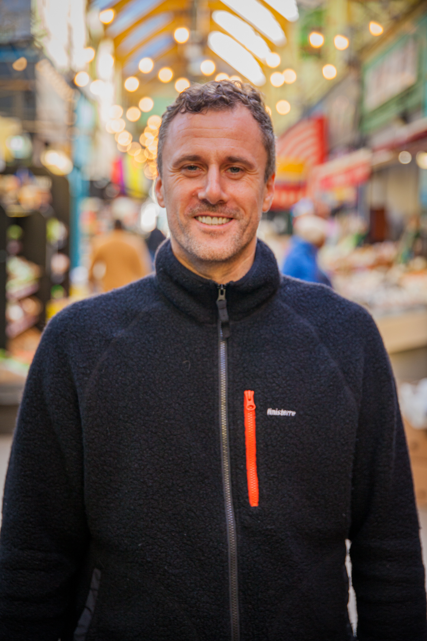 Dirk Bischof smiling in a covered passage at Brixton Market