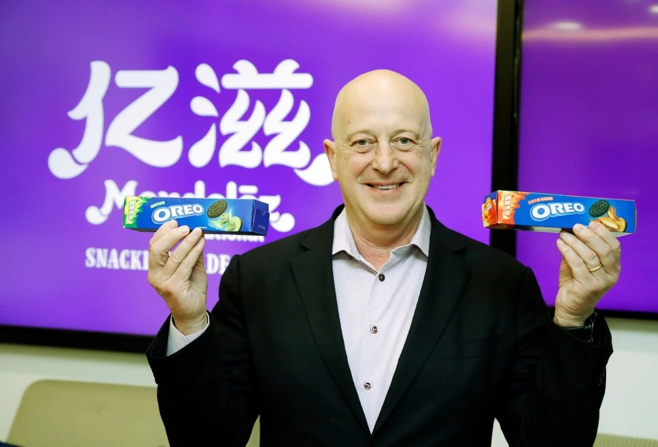 Dirk Van de Put holding wasabi and spicy chicken Oreo packages in China