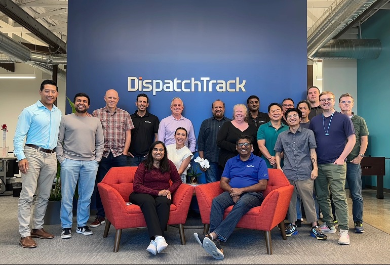 DispatchTrack’s United States team gathered around a red couch in their office