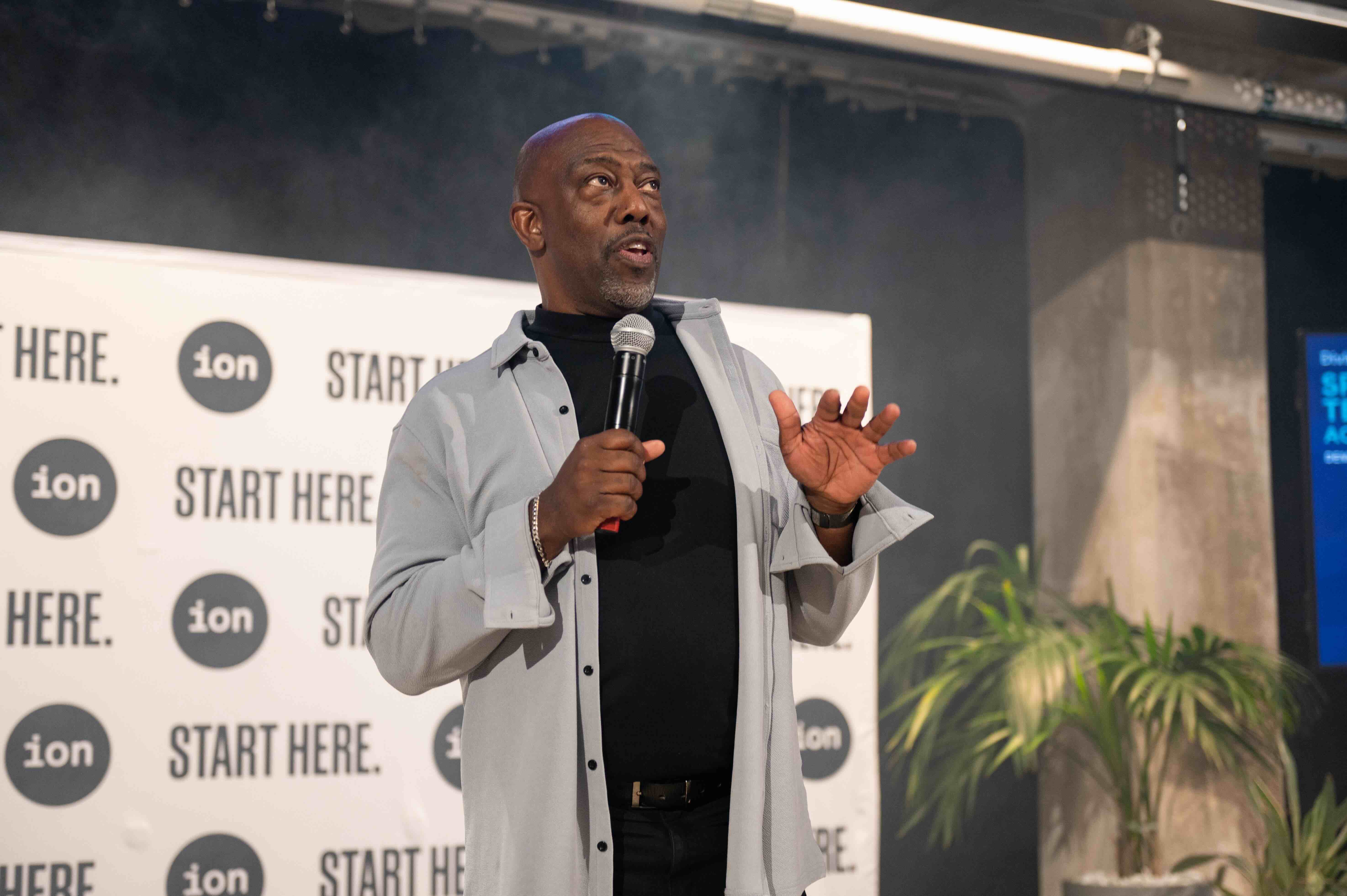Preston James speaking into a microphone at DivInc Demo Day at the Ion