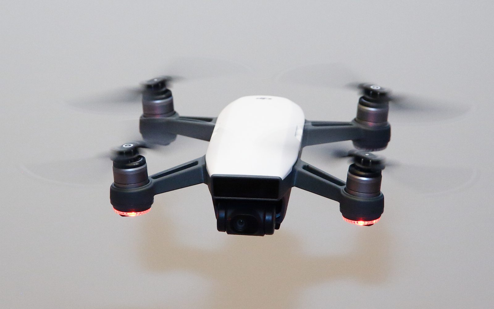 A white DJI Spark drone hovering outdoors