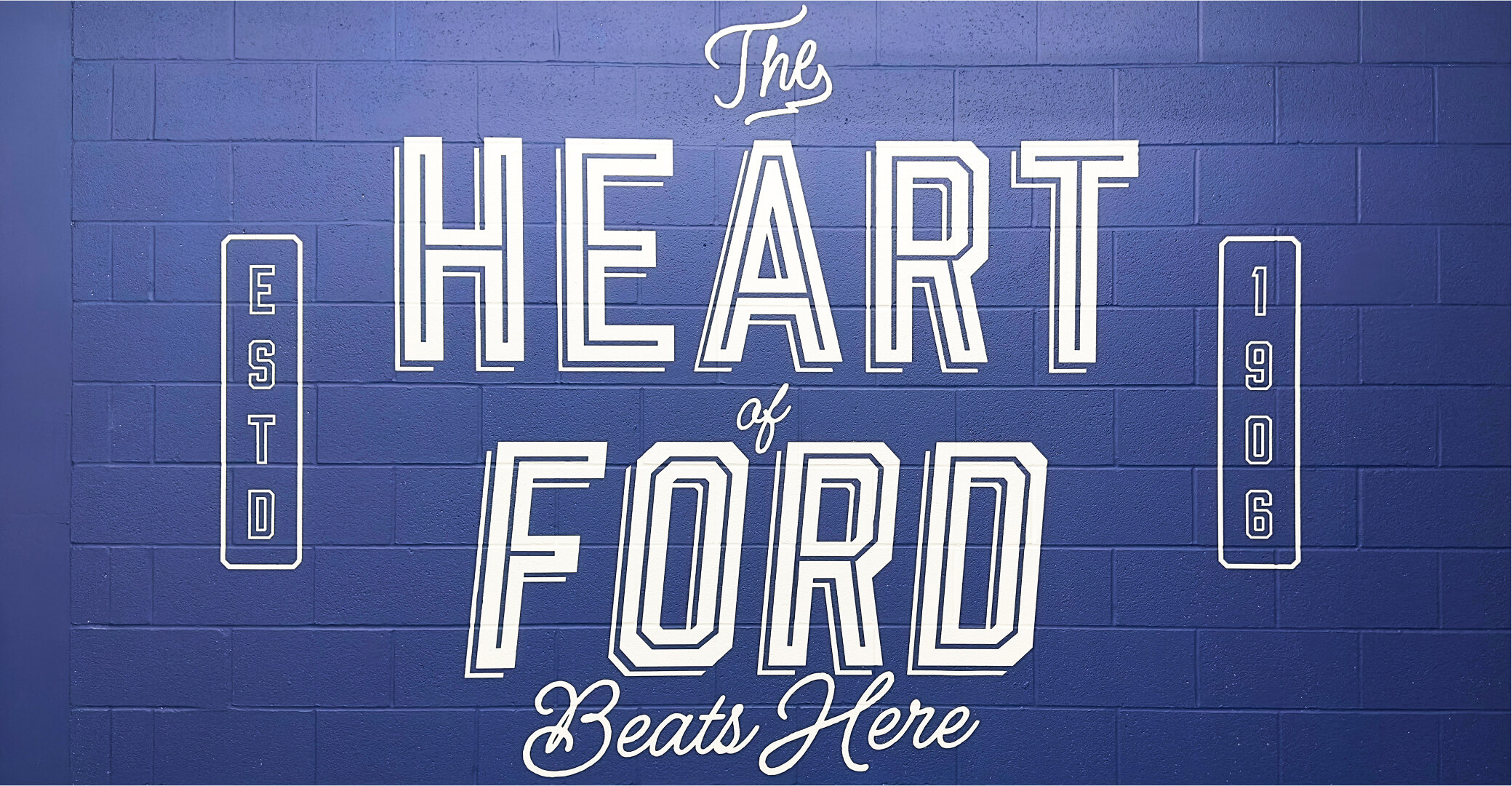 Blue brick wall at Ford Kansas City Assembly Plant painted with The Heart of Ford Beats Here
