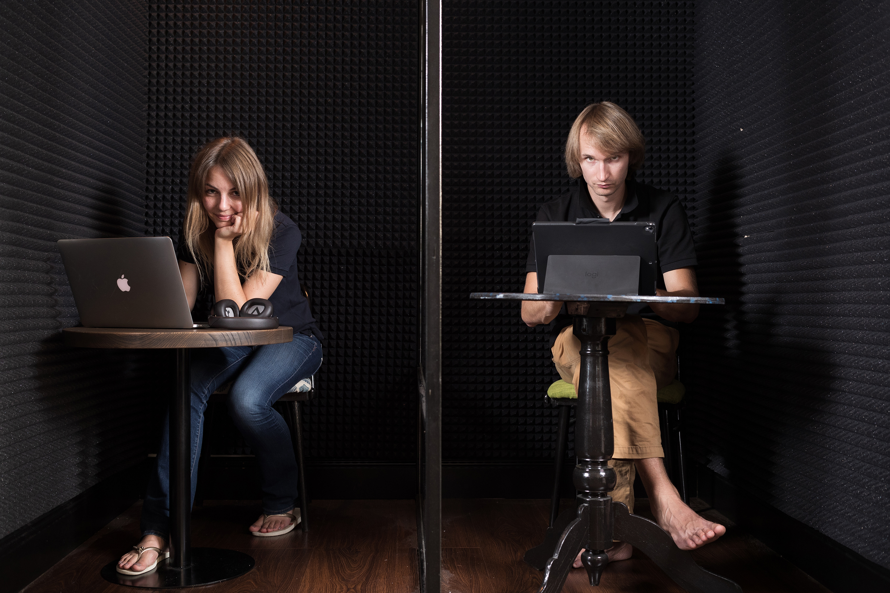 Dmitry Korolev and Maria Khokhlova working on computers in two adjoining sound-lined booths