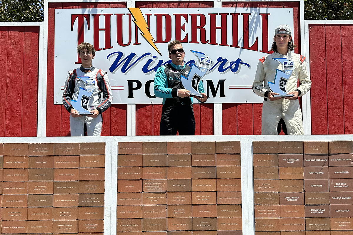 Dmitry Pistolyako at the centre of the Thunderhill F4 podium, holding the first-place trophy, with Preston Lambert and James Lawley