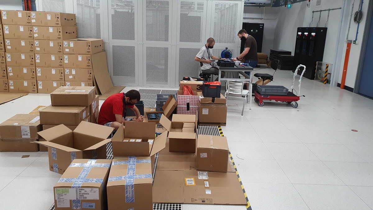 Boxes and equipment spread across a data-center room during setup