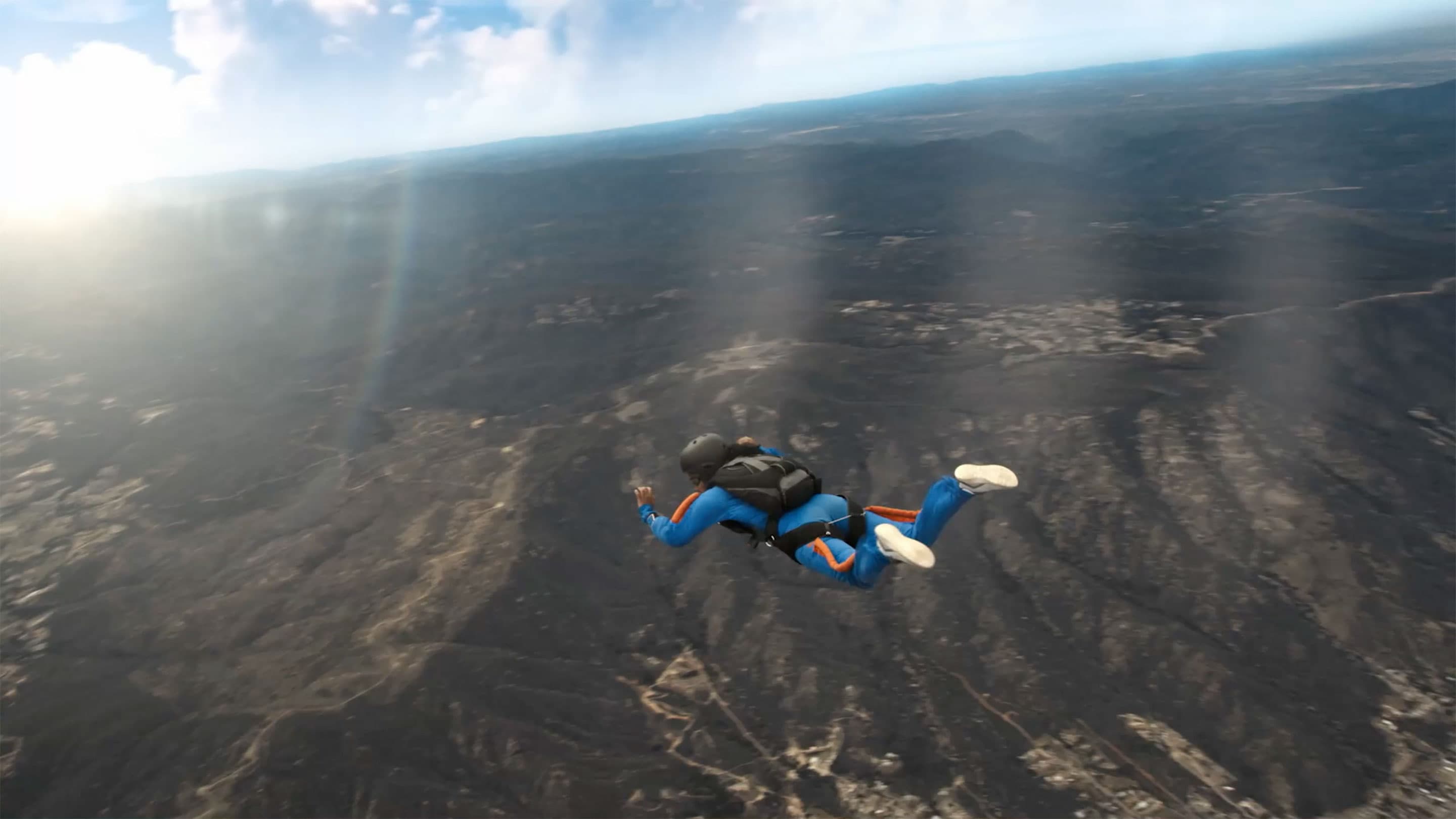 A woman skydiving above a mountain landscape in OhioHealth's Keep Making Plans campaign