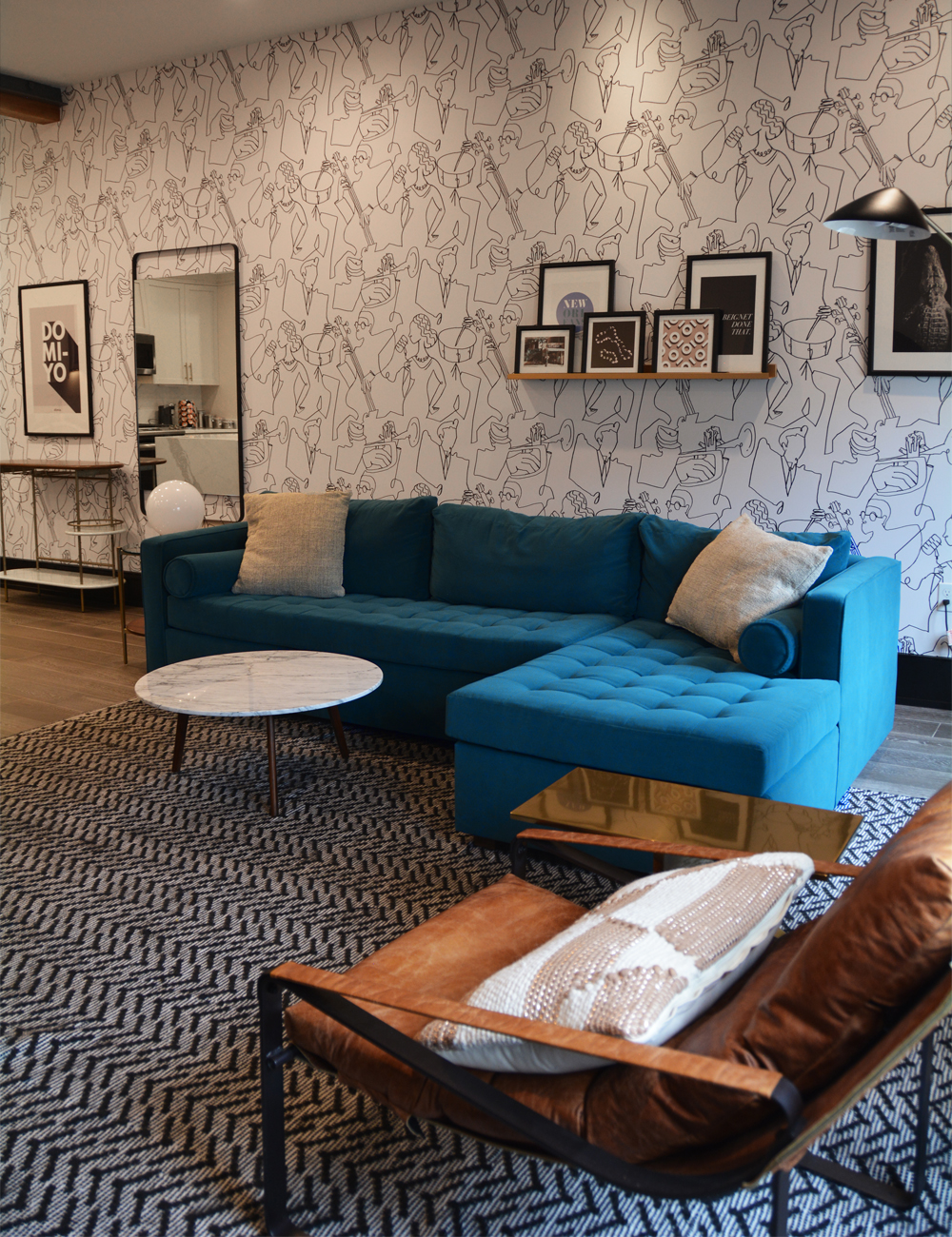 Blue sofa and illustrated jazz musician wallpaper at Domio Baronne Street