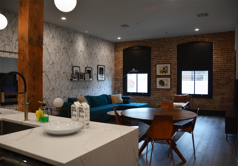 Kitchen, dining table and blue sofa in a Domio Baronne Street apartment