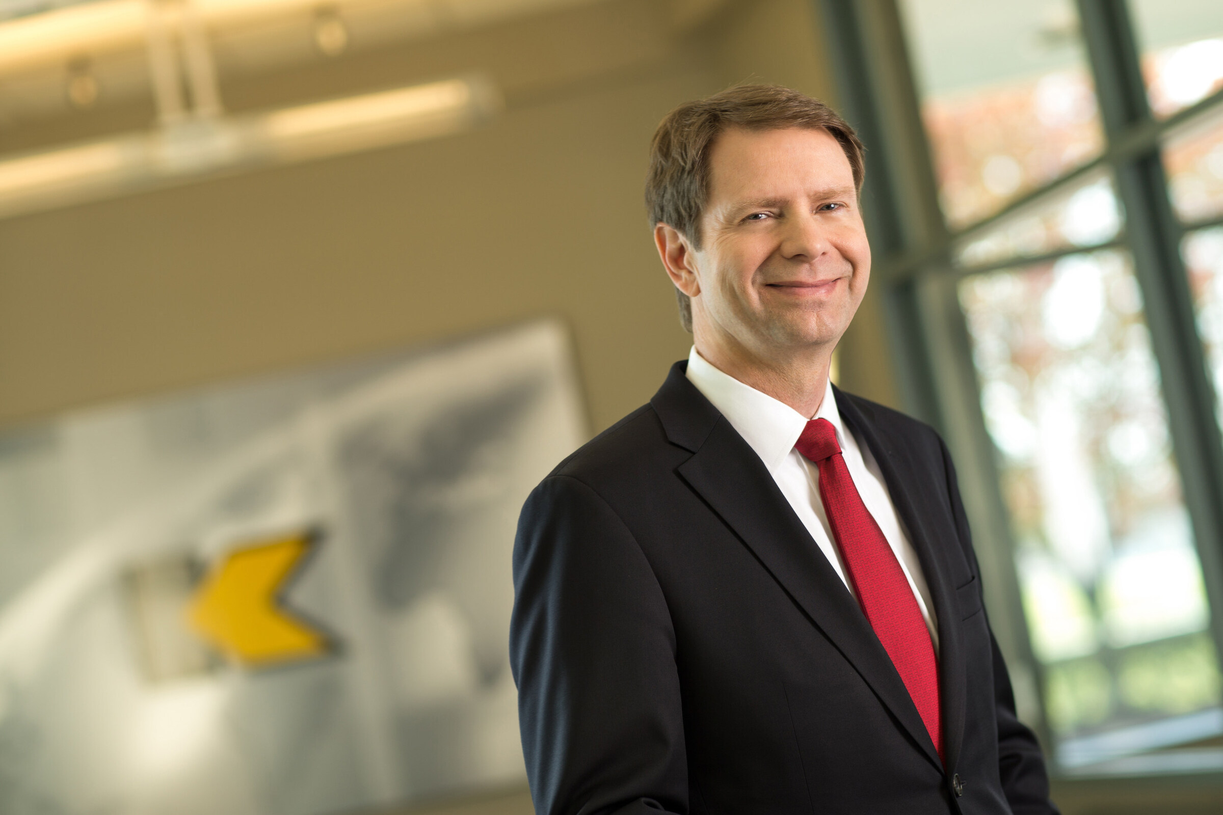 Don Nolan standing at Kennametal, wearing a dark suit and red tie