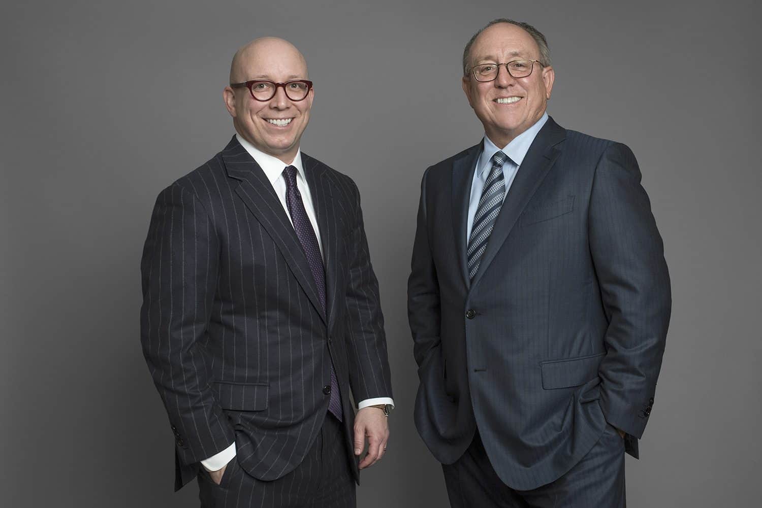 Matt Schreiber on the left and his father Don Schreiber Jr. on the right, standing together in suits.
