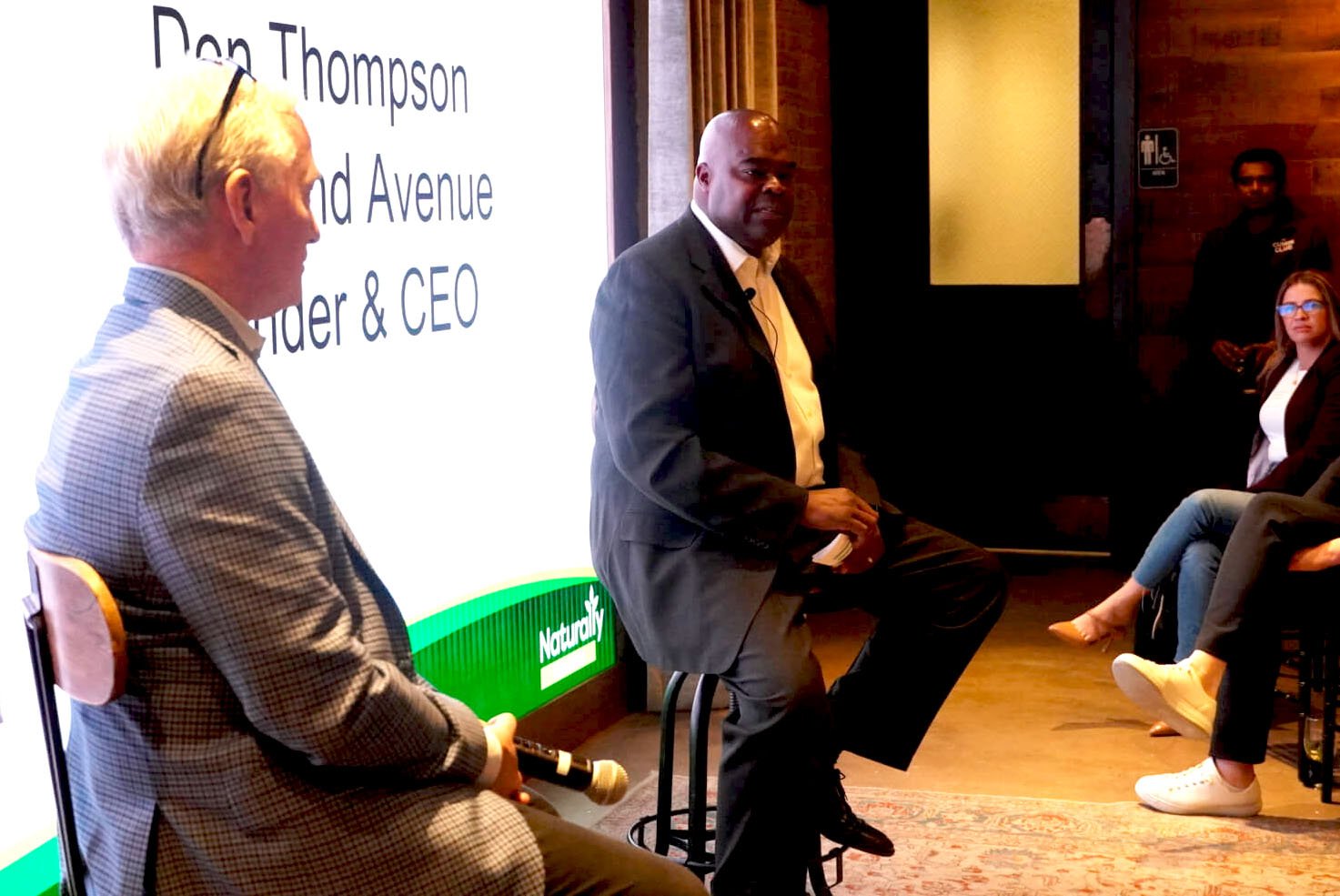 Don Thompson, seated at centre, speaking with Jim Slama and an audience at Taste 222.