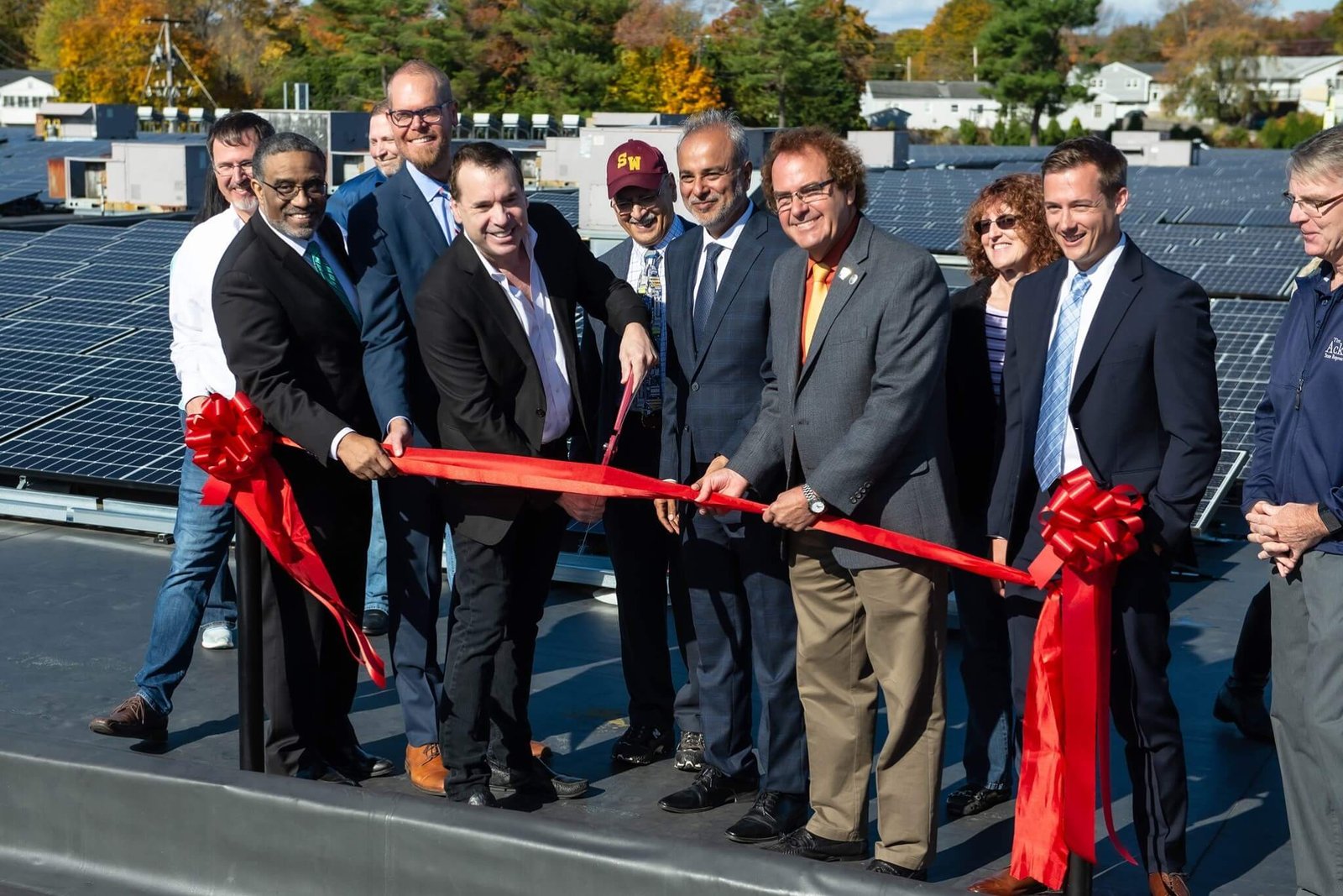 Don Vaccaro and guests cutting a red ribbon among solar panels at TicketNetwork headquarters