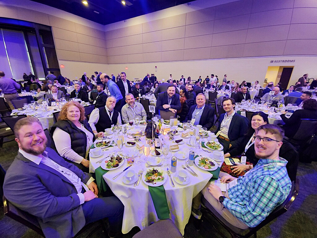 Donovan Advertising team members seated together around a dinner table at a large event