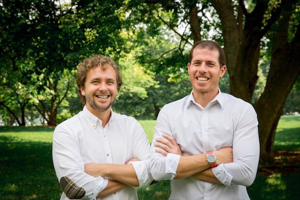 HealthJoy co-founders Justin Holland and Doug Morse-Schindler sitting together and laughing