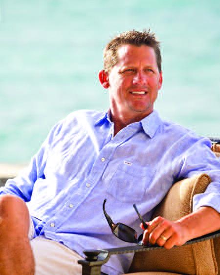 Dougan Clarke seated outdoors in a blue shirt