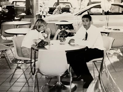 A young Douglas Campbell seated with a customer during his first car sale at Coral Springs Oldsmobile