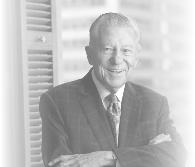 Drake International co-founder Bill Pollock smiling in a suit