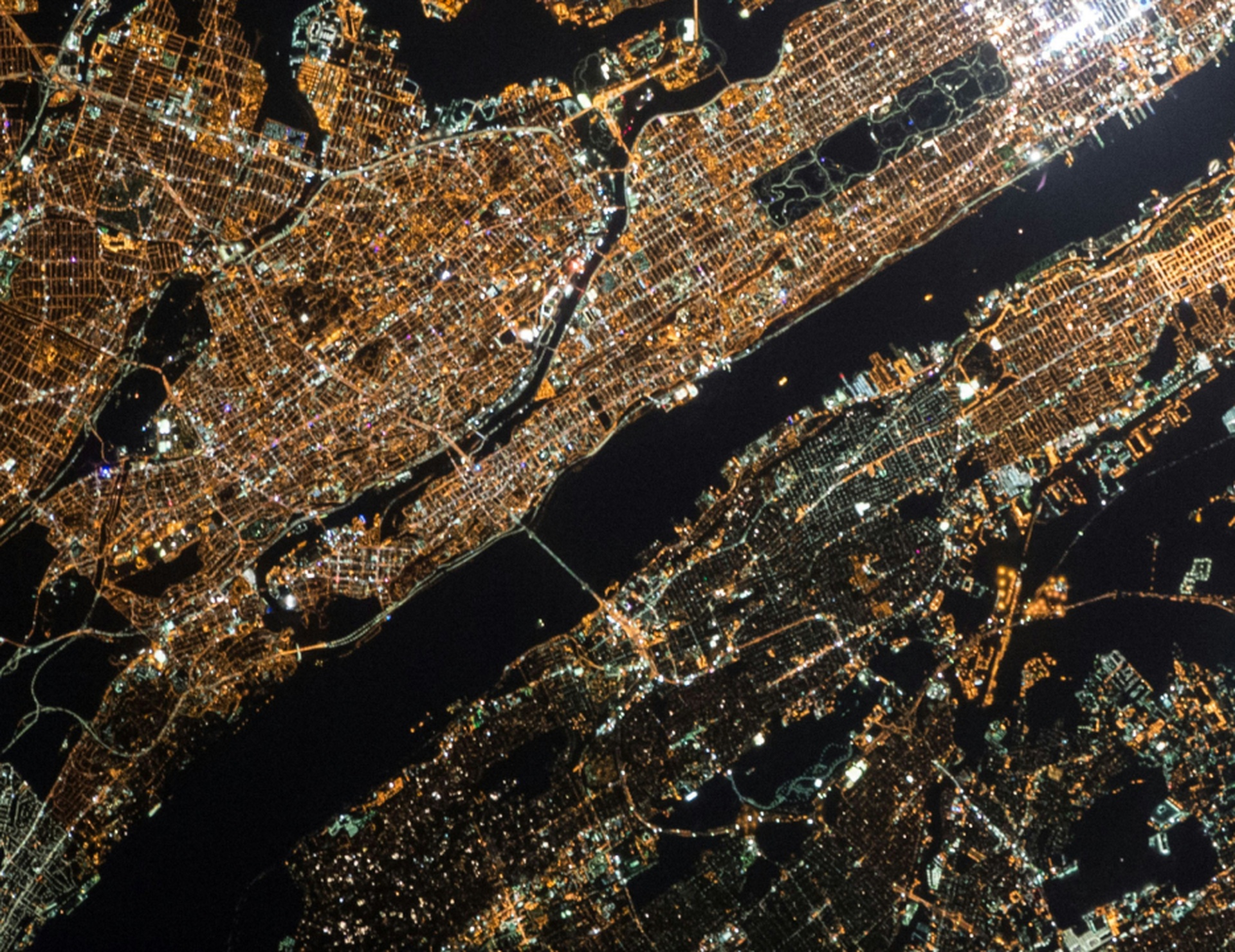 An aerial view of an illuminated city and its waterways at night