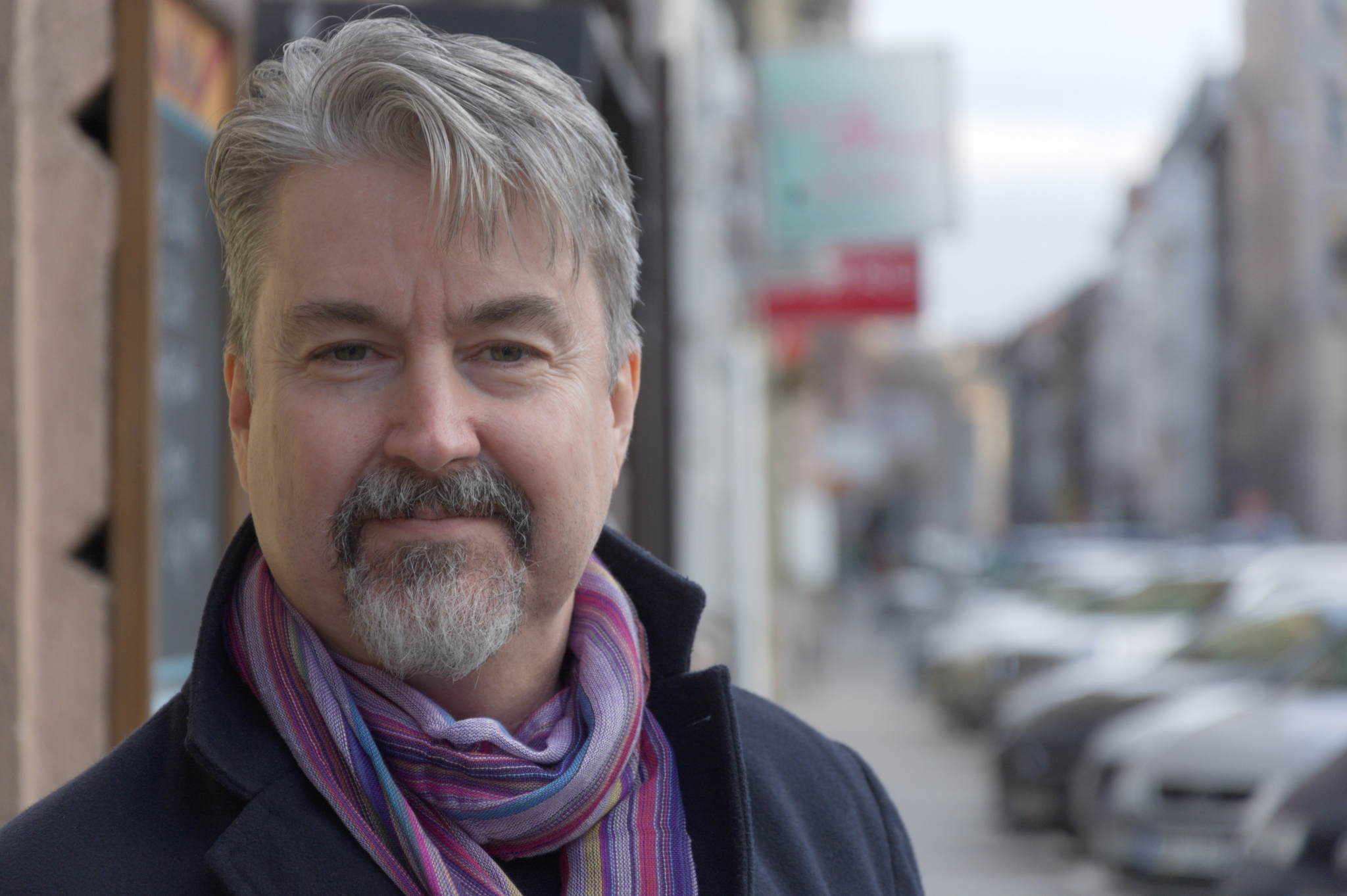 Drew Gerber outdoors wearing a scarf on a city street