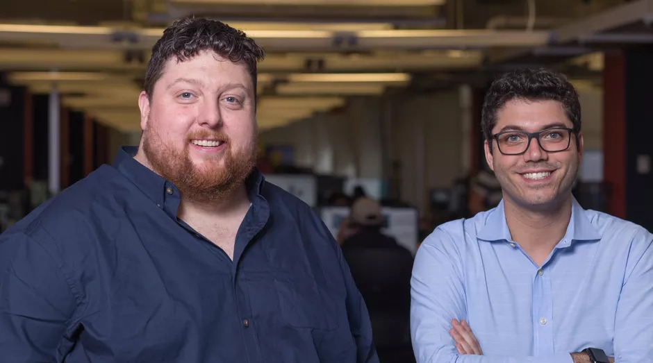 Drew McElroy, left, and Transfix co-founder Jonathan Salama, right, standing together in an office.