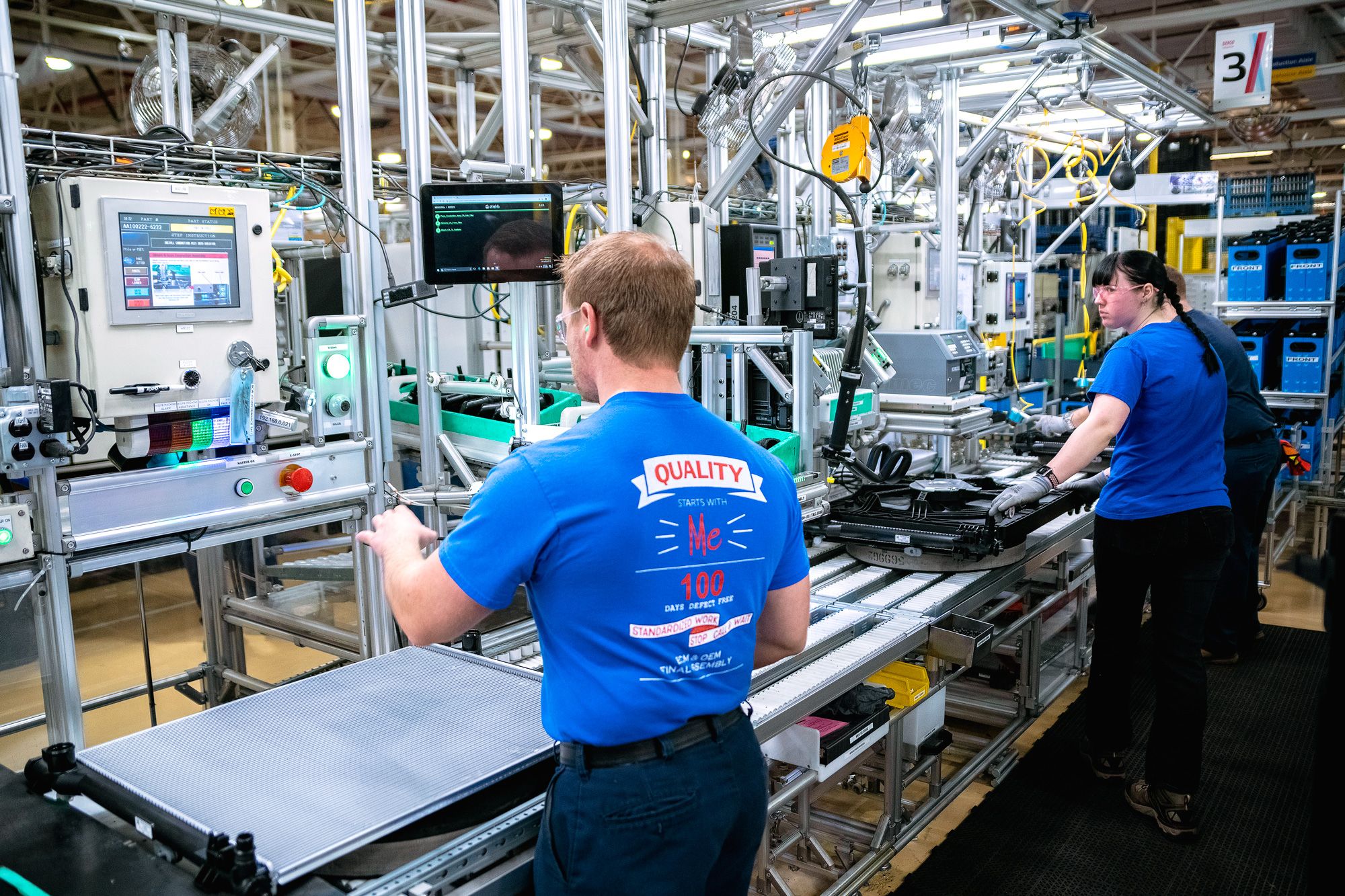 DENSO assembly line workers at a manual production station