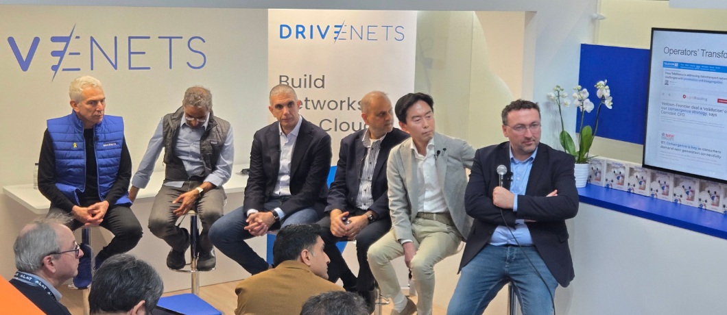 Networking executives seated on a panel at a DriveNets conference booth