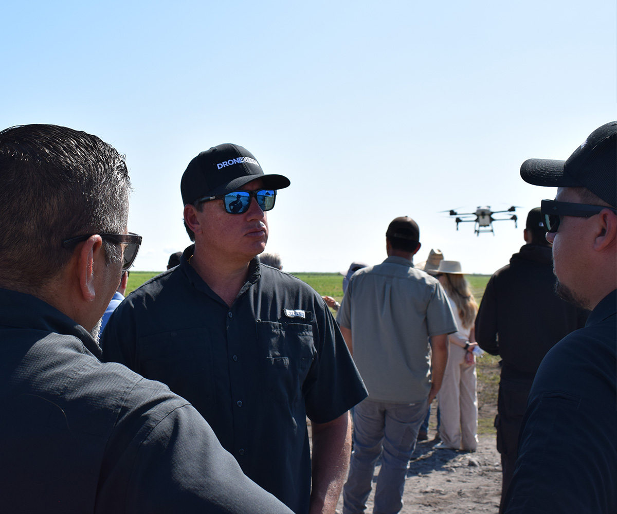 Drone Nerds team members talk during an agricultural drone demonstration in a field