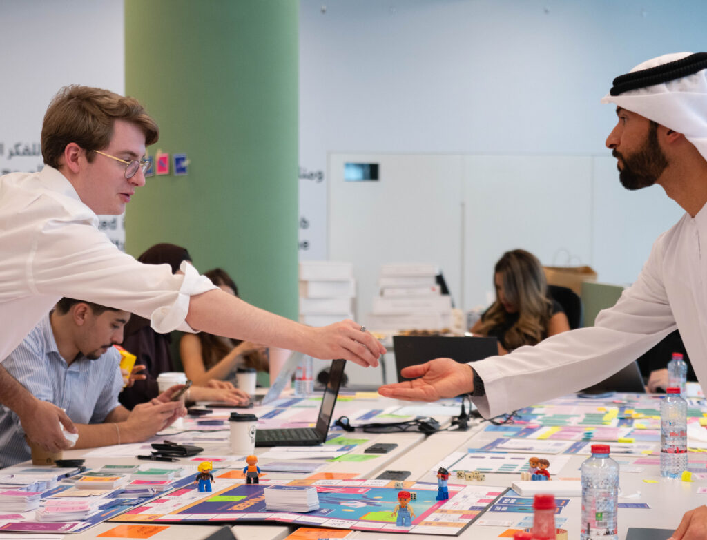 Workshop participants move pieces across a fund-management simulation board