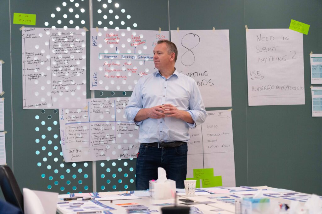 A workshop facilitator stands before handwritten fund-management notes