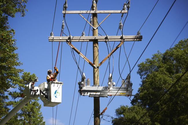 Duke Energy lineworker maintaining equipment on a utility pole