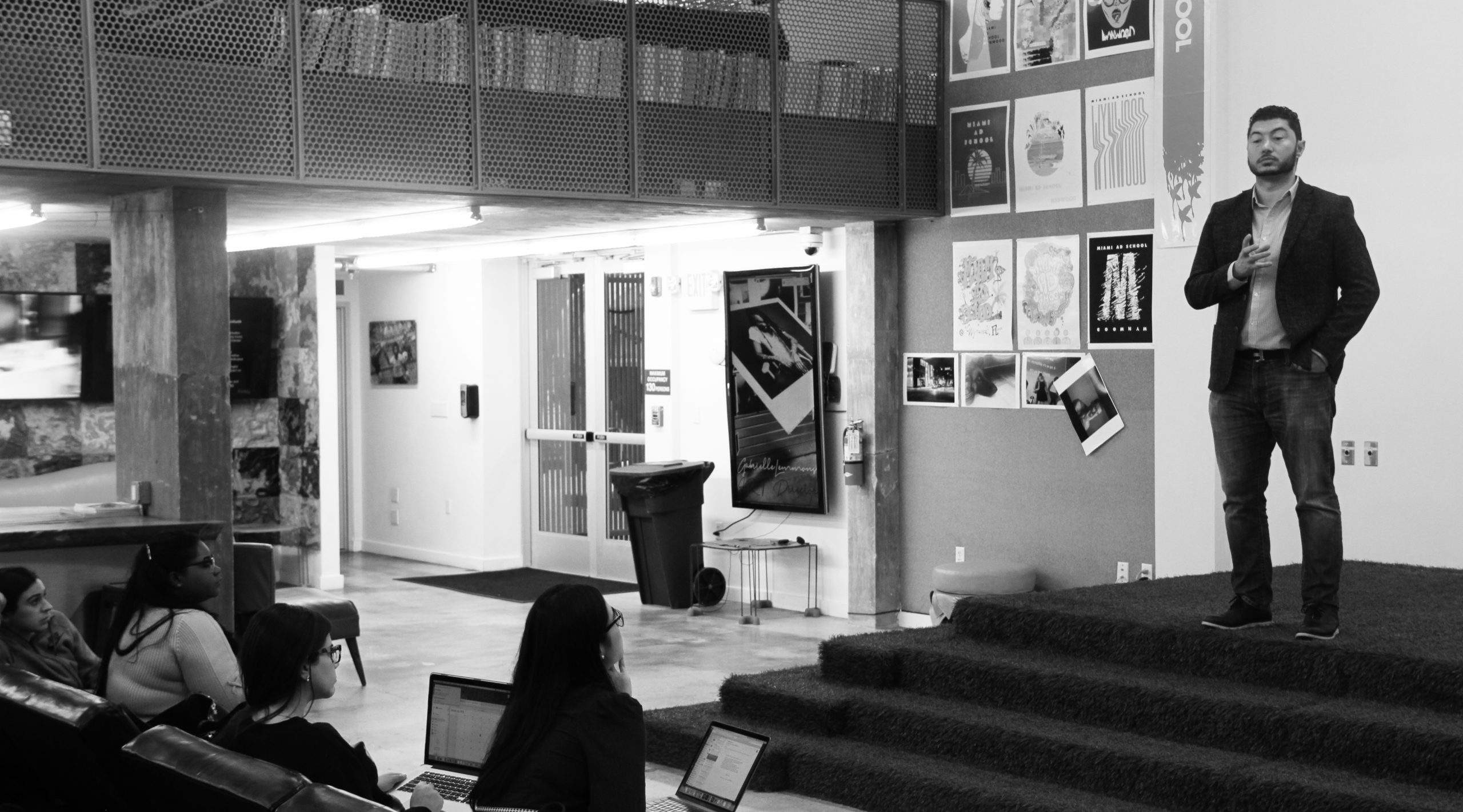Duran Inci speaking to students with laptops in an advertising-school setting