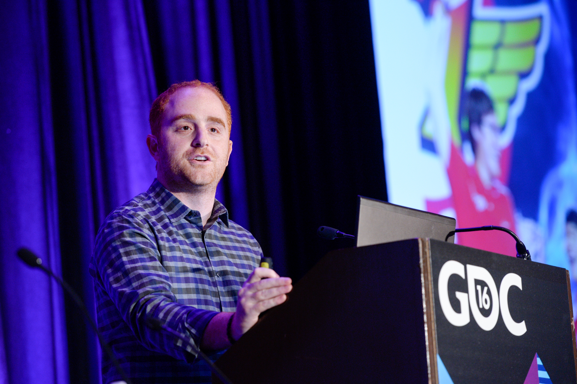 Dustin Beck speaking onstage at the 2016 Game Developers Conference