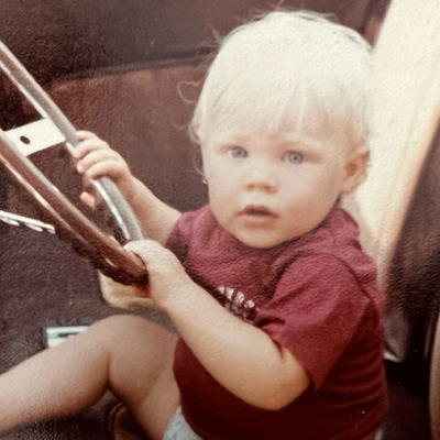 A childhood photograph of Dustin Lee holding the controls of a ride
