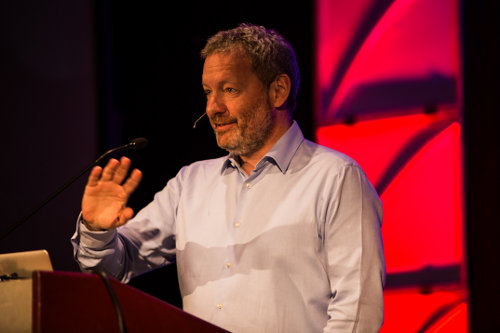 Dwight Merriman speaking at a lectern at All Things Open in 2014