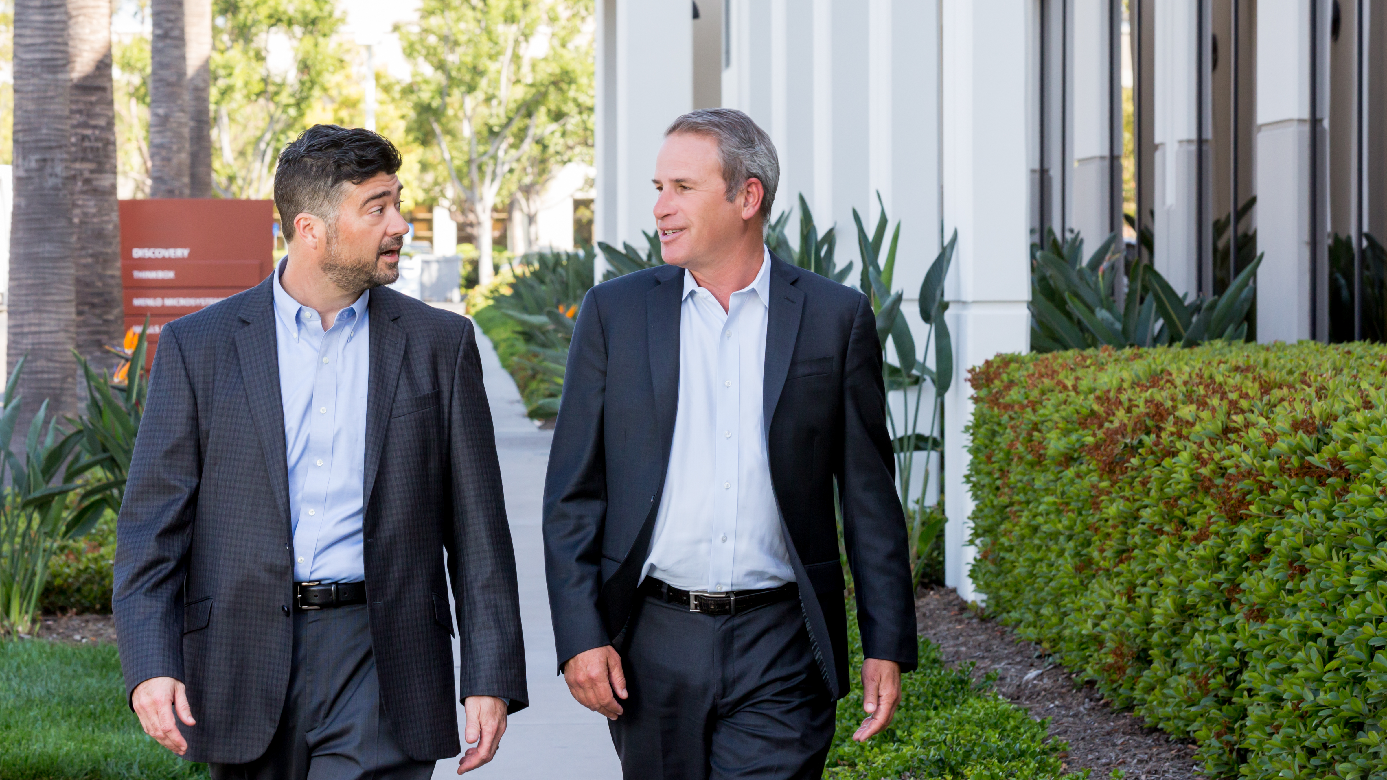 e360 leaders Matthew General and Mike Strohl walking together outside an office