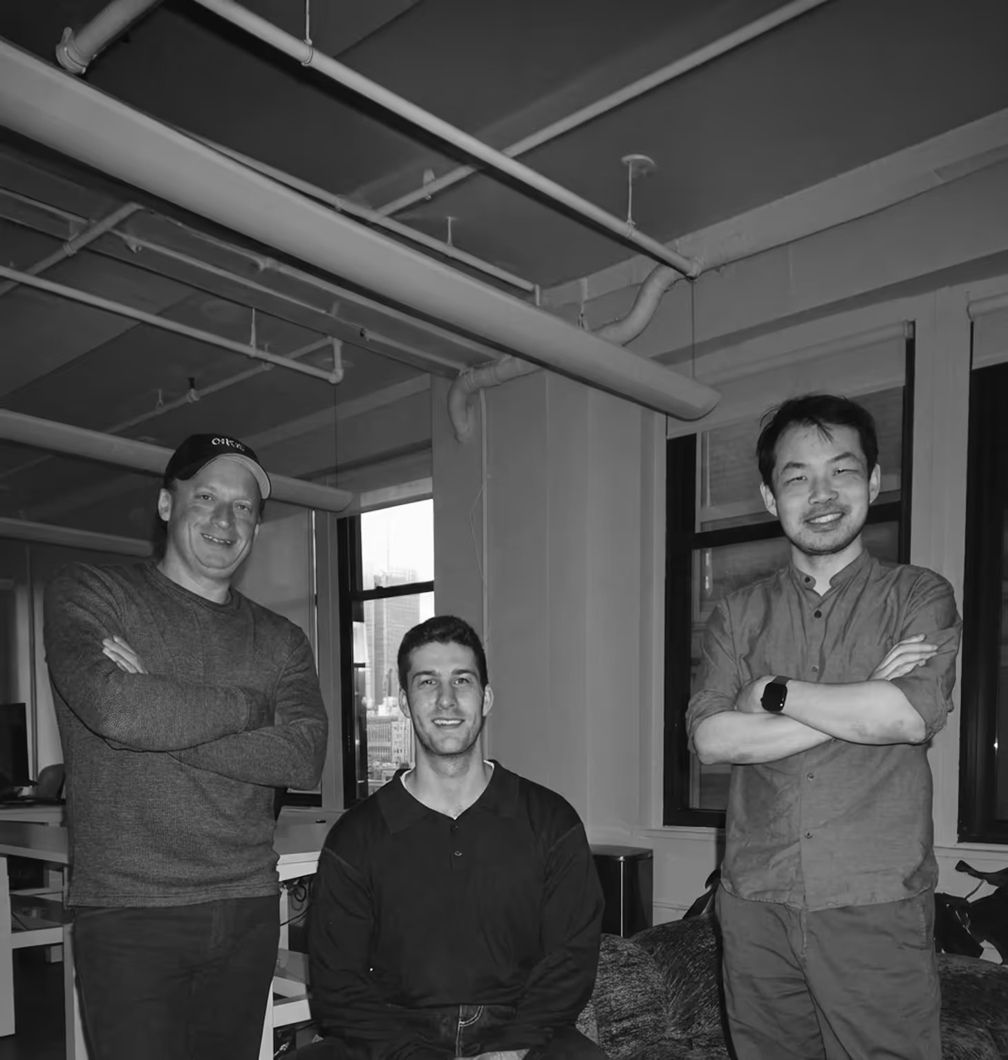 Three members of Ease Health’s team in an office, in an official black-and-white photograph