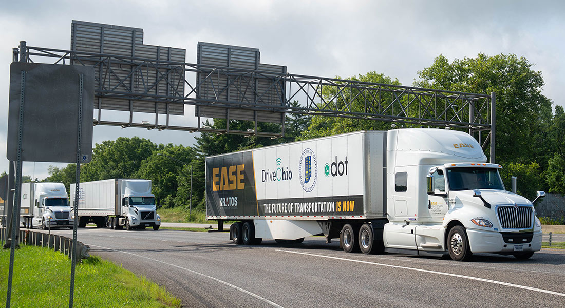EASE trucks bearing DriveOhio, Indiana and Kratos branding on the road