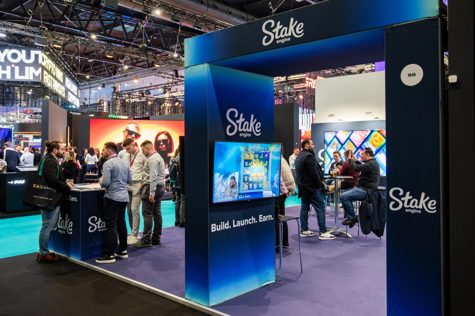 Stake Engine exhibition stand with game screens and attendees
