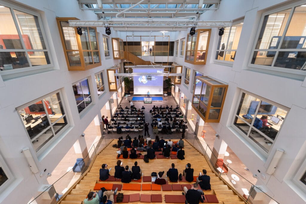An audience gathered in a bright atrium for a FoodSeed event