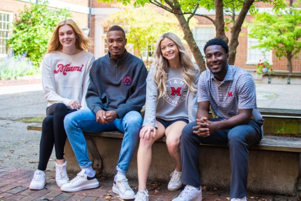 Four students sitting together outdoors in Miami University apparel, in a photograph used on eCampus’s institutional website