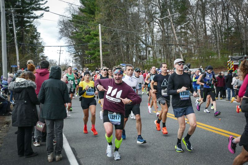 Ed Breault running the Boston Marathon in a burgundy Malbek shirt amid other runners